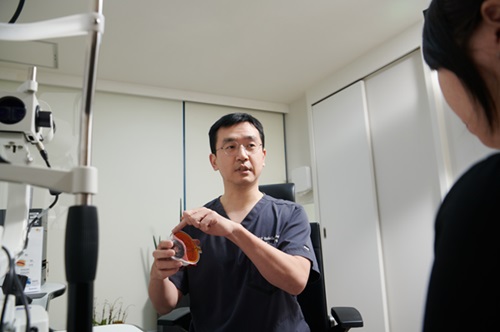 Dr. TaeWan Kim, a retina and cataract treatment specialist, is seen attending to a patient. When necessary, each medical professional collaborates organically with other specialists to provide integrated care.