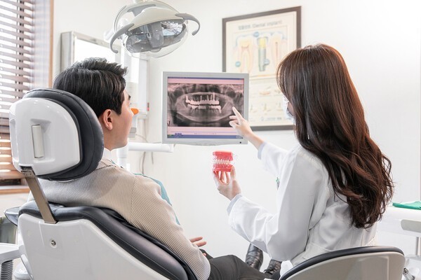A dental professional explains treatment to a patient